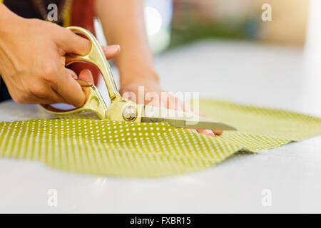 Mains de femme tissu coupe tailleur méconnaissable avec scissor Banque D'Images