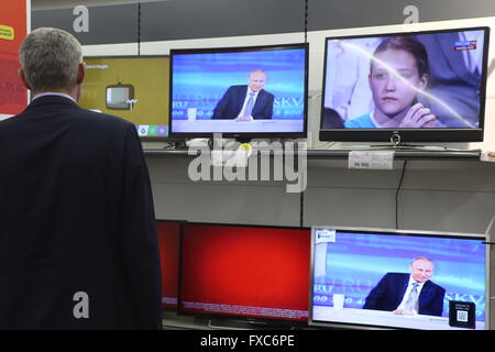 Moscou, Russie. 14 avr, 2016. Un homme regarde la télévision séance de questions-réponses du Président russe Vladimir Poutine à Moscou, Russie, le 14 avril 2016. Credit : Evgeny Sinitsyn/Xinhua/Alamy Live News Banque D'Images