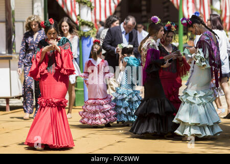 Séville, Espagne. 14 avr, 2016. Des femmes habillées avec robe flamenco typique d'utiliser leurs téléphones mobiles à la ''Feria de Abril'' (avril 2016) du salon © Daniel Gonzalez Acuna/ZUMA/Alamy Fil Live News Banque D'Images