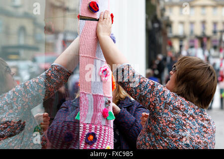 Bath, Royaume-Uni, le 14 avril, 2016. Les bénévoles dirigé par Emma Leith illustrés dans Milsom Street comme ils l'enrouler de la laine lampadaires dans le cadre d'un fil de bienfaisance au profit de la bombe RUH Cancer Care Appel. Pour chaque poster enveloppé avec de la laine, Mulberry a promis €100 à l'organisme de bienfaisance.L'événement kick démarre la semaine de la mode en 2016 baignoire,la semaine fête de la mode commence le 18 avril. Credit : lynchpics/Alamy Live News Banque D'Images