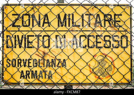 Panneau jaune qui lit dans la zone "Militaire italienne, pas d'entrée, de surveillance armés". Banque D'Images