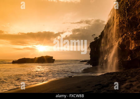 Coucher du soleil à Melasti Beach avec une cascade près du temple de Tanah Lot Banque D'Images