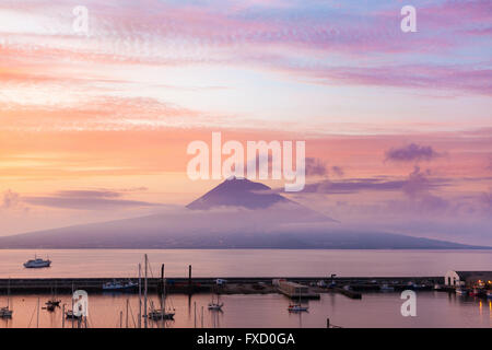 Le mont Pico, l'île de Pico, région autonome des Açores, au lever du soleil. Port de Horta, île de Faial, en premier plan Banque D'Images