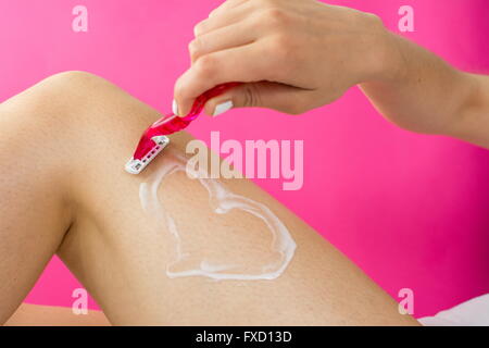 Femme de sa jambe avec forme de coeur fabriqué à partir de mousse Banque D'Images