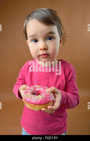 Little girl with sweet donut Banque D'Images