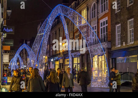 Personnes marchant le long de South Molton St à l'heure de Noël, qui a été décoré avec de grandes arches de Noël bleues, Londres, Royaume-Uni Banque D'Images