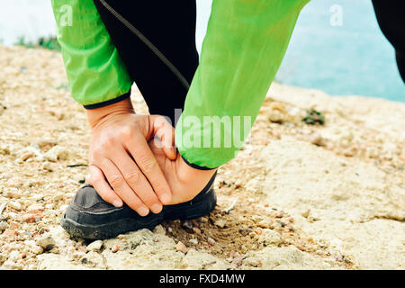 Closeup of a young caucasian sportsman portant des vêtements de sport étend ses jambes avant ou après l'exécution Banque D'Images