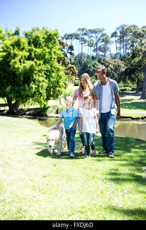 Balades en famille dans le parc avec leur chien Banque D'Images