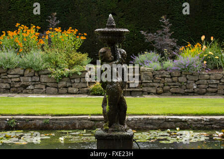 Une belle salle, traditionnelle, paysagée, country garden, West Yorkshire, Angleterre - bassin d'agrément, fontaine et fleurs herbacées frontière. Banque D'Images