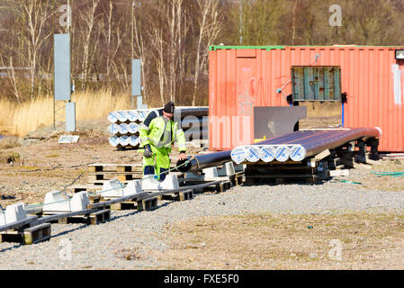 Karlskrona, Suède - 7 Avril 2016 : Assemblée Générale de conduite d'égout sous-marine en zone publique. Ici un homme est le montage d'une ligne à la Banque D'Images
