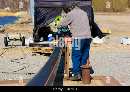 Karlskrona, Suède - 7 Avril 2016 : Assemblée Générale de conduite d'égout sous-marine en zone publique. Ici un homme est à l'aide d'un treuil motorisé Banque D'Images
