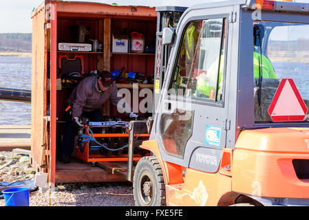 Karlskrona, Suède - 7 Avril 2016 : Assemblée Générale de conduite d'égout sous-marine en zone publique. Ici deux travailleurs d'une vis de transport Banque D'Images