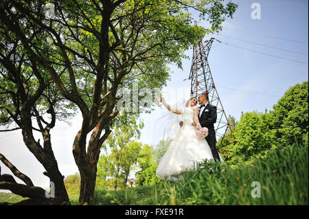 Happy wedding couple à la mode tour électrique de fond à l'autre Banque D'Images