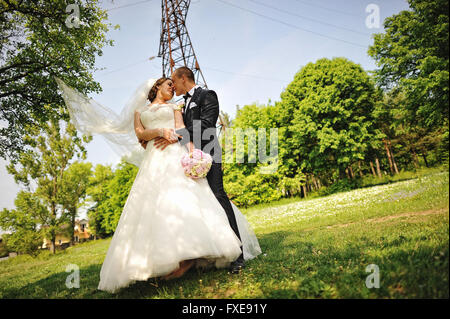 Happy wedding couple à la mode tour électrique de fond, moment pour kiss Banque D'Images