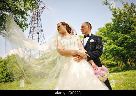 Couple de mariage à la mode tour électrique de fond, long voile de mariée. Banque D'Images