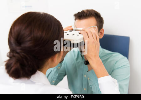 Opticien avec pupillometer et patient à la clinique Banque D'Images