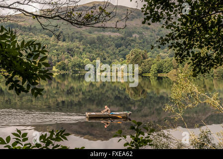 Un pêcheur solitaire dans son bateau sur Grasmere dans le Lake District. La région de Cumbria. Nord-ouest de l'Angleterre. Banque D'Images