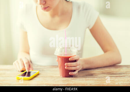 Close up of woman with smartphone smoothie et Banque D'Images