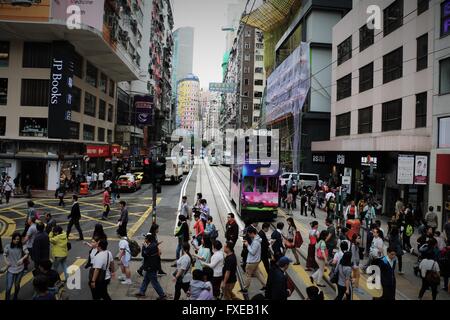 Un grand nombre de personnes qui traversent la rue en populaires Causeway Bay à Hong Kong. Tramway colorées en arrière-plan. Couverture du livre Banque D'Images