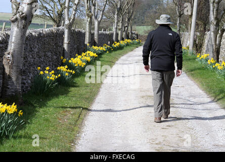 Walker sur un sentier public qui passe par une ferme dans le parc national de Peak District Banque D'Images