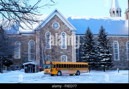 Vue d'une église en hiver avec un bus scolaire jaune au premier plan dans la ville de Québec, Québec, Canada. Banque D'Images