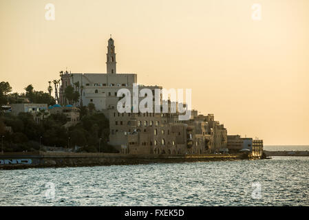 Coucher de soleil sur la mer Méditerranée à Tel Aviv, Israël. Vue sur la vieille ville de Jaffa avec clocher de l'église franciscaine de Saint Peter Banque D'Images