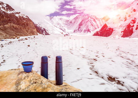 Deux thermos de voyage Bleu bouteilles Thermo et tasse sur la pierre et le camp de base en haute montagne Banque D'Images