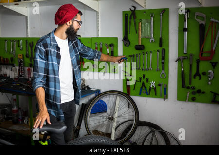 Mécanicien vélo ramasser des outils pour réparer un vélo Banque D'Images