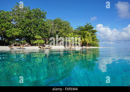 Plage tropicale d'un îlot avec tables de pique-nique sur la rive, vu à partir de la surface de l'eau, l'île de Huahine, Polynésie Française Banque D'Images