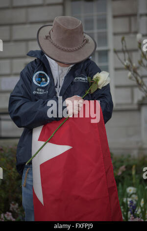Belfast, Royaume-Uni. 15 avr, 2016.Un membre de la société Titanic Belfast est titulaire d'une rose jaune et la White Star Line Flag s'incline la tête en souvenir des 1512 personnes qui ont péri dans le RMS Titanic. Lord Maire de Belfast Arder Carson, déposé des couronnes marquant le 104e anniversaire du naufrage du RMS Titanic. Credit : Bonzo/Alamy Live News Banque D'Images