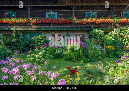 Ancienne ferme, balcon avec des géraniums (Pelargonium spec.), devant un jardin de fleurs, jardin de curé, Piesenkam, Isarwinkel Banque D'Images