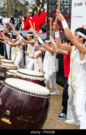 Tambours Taiko, de kumi-daiko concert. Vue de côté de la rangée d'enfants et adolescents en costume de tambours traditionnels, battant de ligne nagado-daiko tambours. Banque D'Images