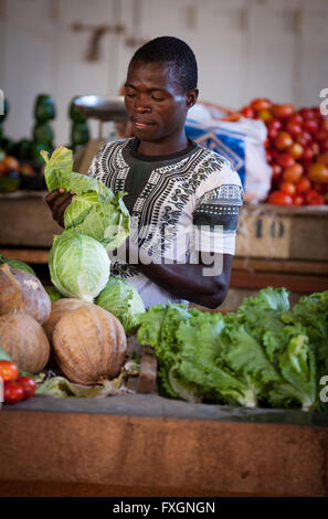 Le Mozambique, l'Afrique, un homme vente de légumes au marché de la ville. Banque D'Images