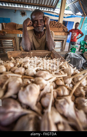 Le Mozambique, l'Afrique, un homme la vente de l'ail et l'oignon au marché de la ville. Banque D'Images