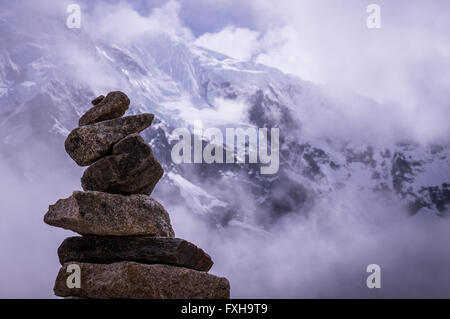 Cusco, Pérou en Octobre 2015 : une pile de rochers en face d'une montagne de neige. Tas de roches sont souvent utilisés comme marqueurs de façon fo Banque D'Images