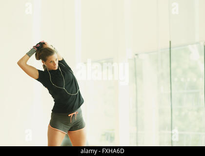 Fit woman stretching arm in gym studio mirror Banque D'Images