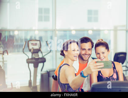 Smiling friends en tenant à gym selfies Banque D'Images