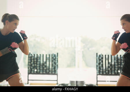 Reflet de femme shadow boxing at gym studio mirror Banque D'Images