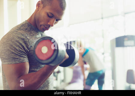 L'accent man doing biceps haltère at gym Banque D'Images