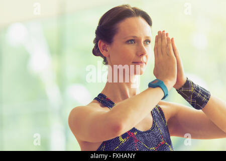 Femme calme avec mains en position de prière dans la classe de yoga Banque D'Images