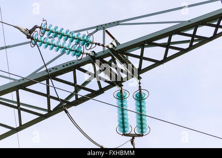 Les isolateurs de la traverse et de la tension à un tour d'une ligne à haute tension Banque D'Images