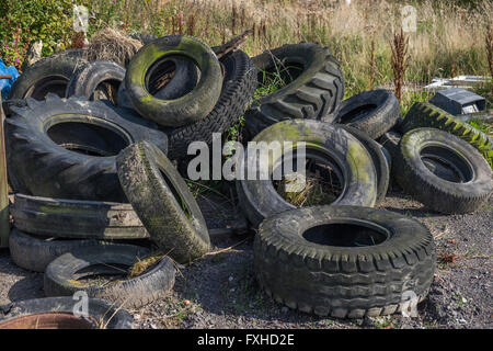 Variété de vieille voiture abandonnée, de tracteur et de pneus de camion ou d'une ferme à gauche Banque D'Images