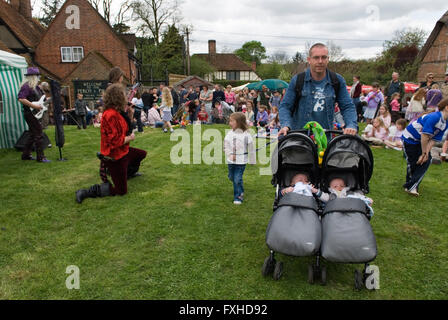 Poussette double. Père poussant ses jumeaux dans une poussette double, une poussette à une foire du jour de mai. Glam Rock Band, The look at the Perch et Pike pub South Stoke Berkshire UK 2016 2010s UK. HOMER SYKES Banque D'Images