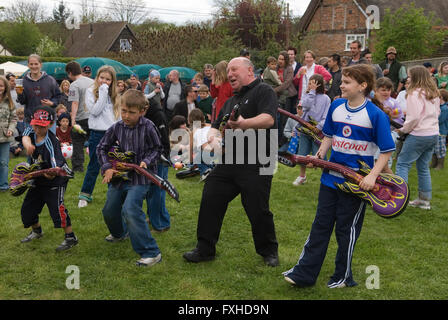 Enfants prétendant jouer de la guitare, jouant avec une guitare soft top. May Day Fair Glam Rock Band The look the Perch and Pike pub South Stoke Berkshire UK HOMER SYKES Banque D'Images