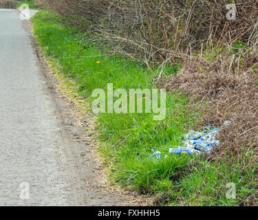 Des canettes de bière et des bouteilles d'un dumping sur le côté d'un chemin de campagne au Royaume-Uni, un exemple de laisser les déchets dans les zones rurales Banque D'Images