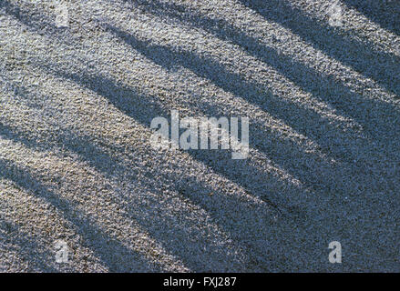 Close-up détaillé des motifs dans le sable de la plage ensoleillée Banque D'Images