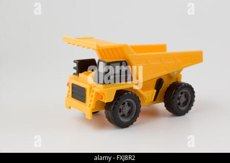 Petite voiture dump truck est jaune sur fond blanc Banque D'Images