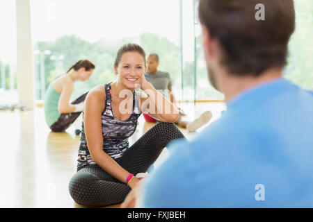 Smiling Woman talking to man at gym Banque D'Images