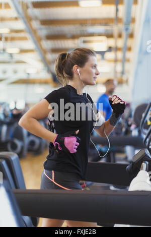 L'accent femme tournant sur tapis roulant à la salle de sport Banque D'Images