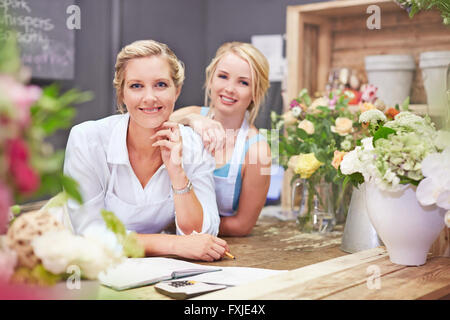 Portrait smiling fleuristes in flower shop Banque D'Images